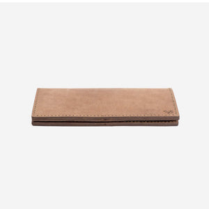 a natural tan leather wallet lying flat on a whit surface with hand stitching and etched logo details. 