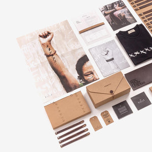 Flatlay of a pack of leather products including 50 wristbands, a Loyal Workshop fair-trade T-shirt, a leather wallet and a USB stick.